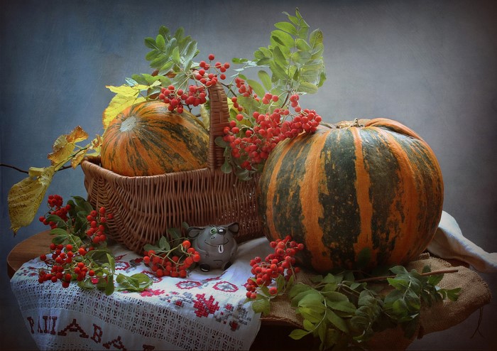 Still-life with pumpkins, rowan berries, and a wicker basket