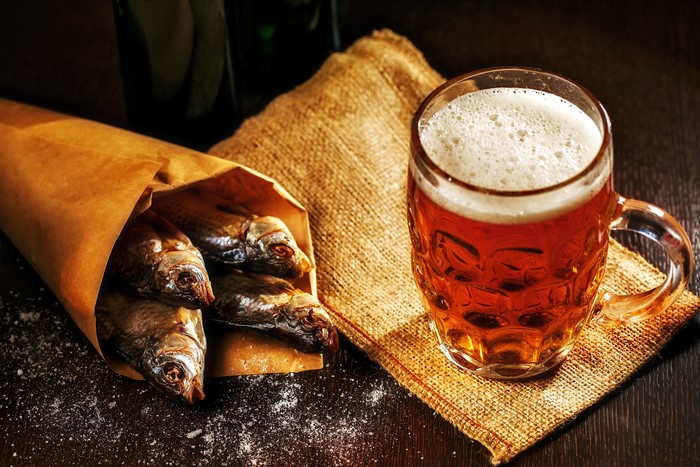 Beer and dried fish in a paper bag