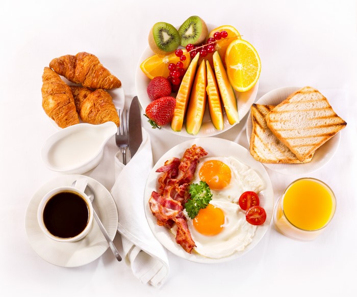 Breakfast with Coffee, Croissants, Fried Eggs, Bacon, Fruit, and Toast