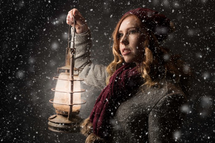 Woman holding a lantern in the snow