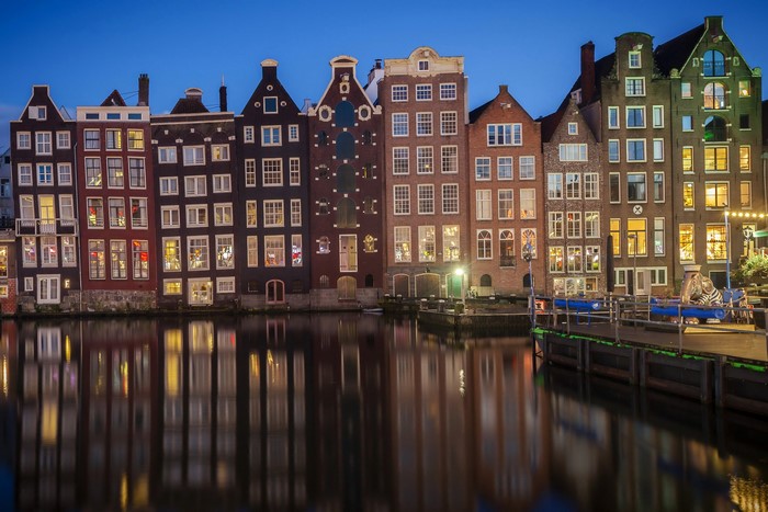 Amsterdam canal houses at dusk with reflections