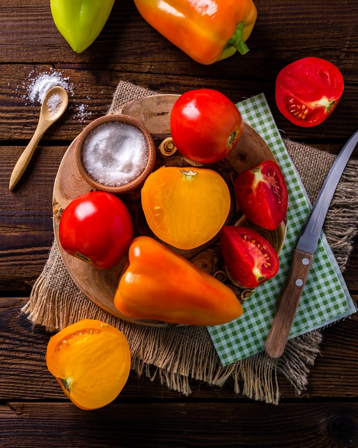 Tomatoes, Bell Peppers, Salt, and Knife on Wooden Table
