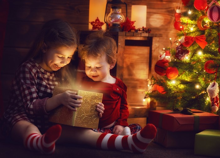 Two children opening a Christmas gift