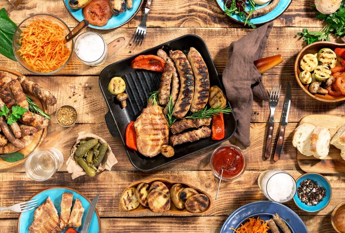 Barbecue spread with sausages, meat, grilled vegetables, and pickles