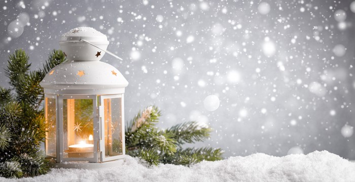 White lantern with candle in snow