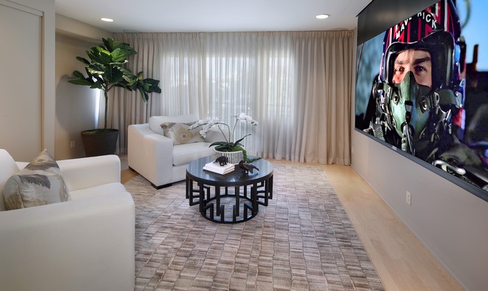 Living room with projector screen showing Top Gun: Maverick