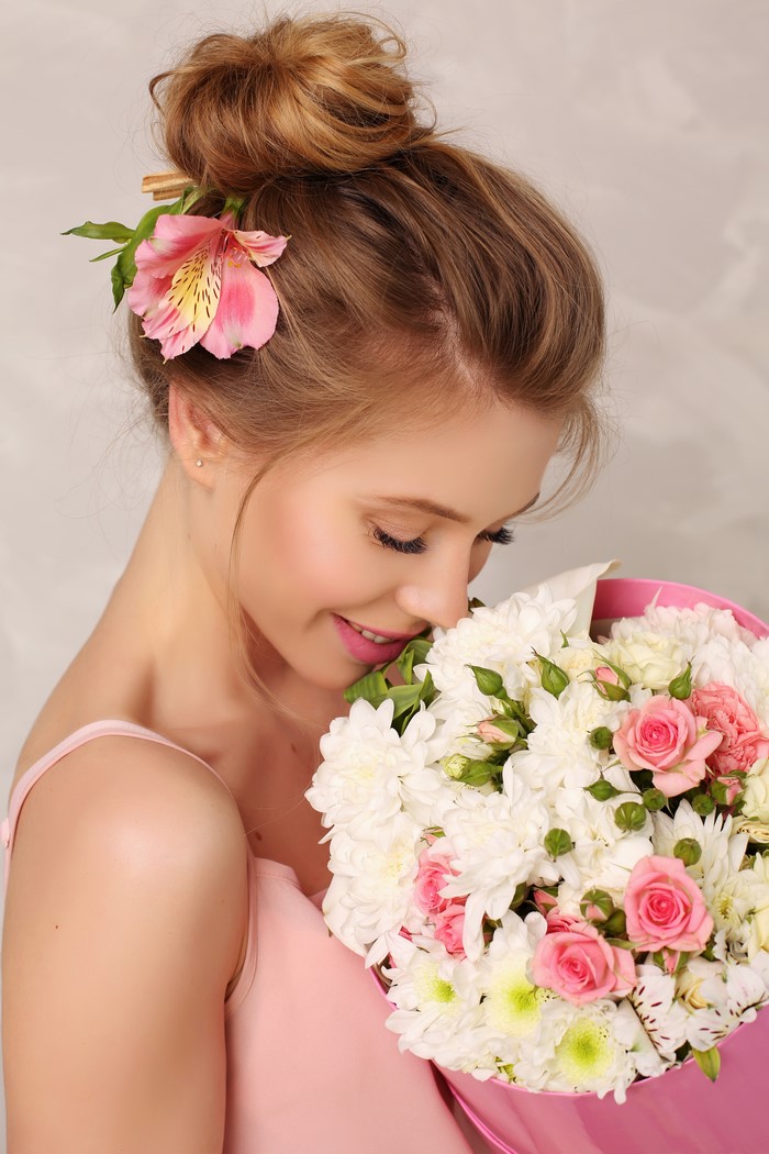 Woman with flower in hair holding bouquet