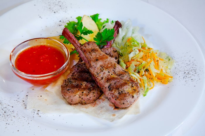 Grilled lamb chops with salad and sauce
