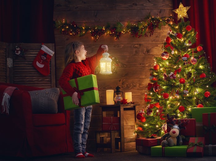 Girl with Lantern and Gift by Christmas Tree