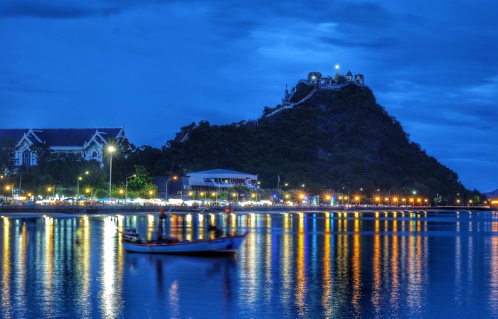 Coastal town at dusk with temple on hill