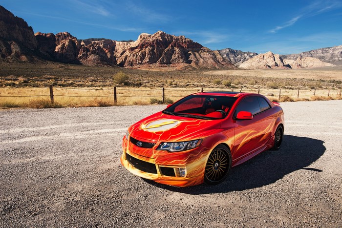 Red Kia Forte Koup with Flash Decals in Desert Landscape