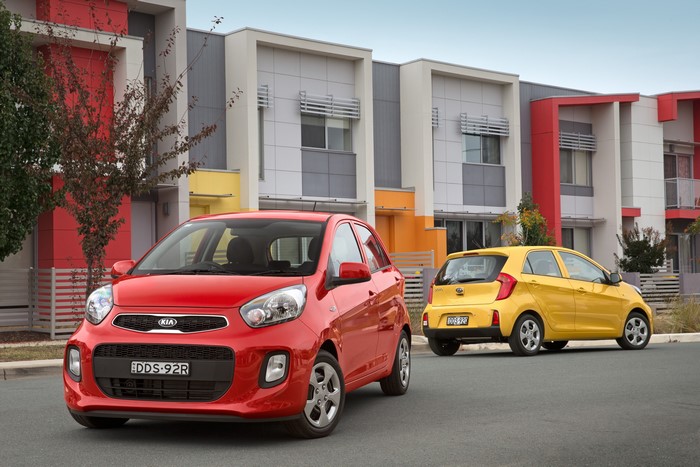 Two Kia Picanto cars parked in front of modern houses