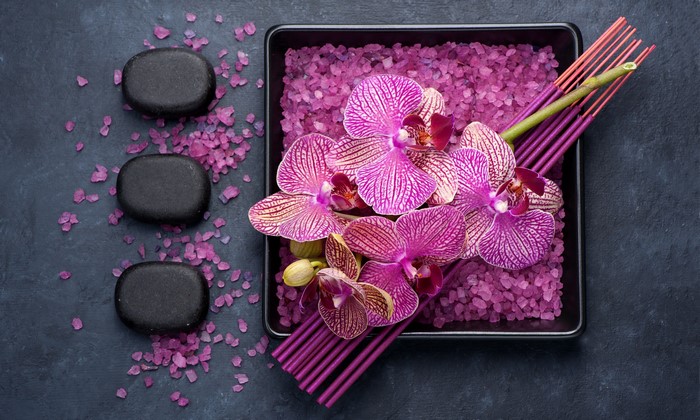 Orchids, spa stones, and incense sticks with purple salt