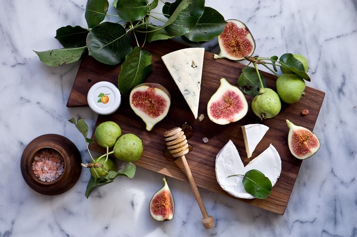Cheese, Figs, Pears, and Honey on a Cutting Board