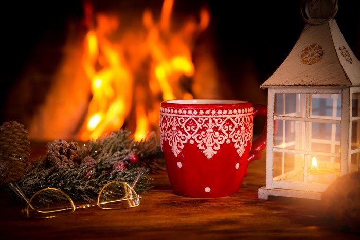 Christmas mug and lantern by fireplace