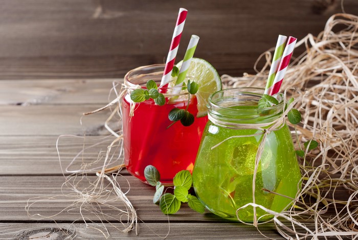 Two colorful drinks in jars with straws and mint