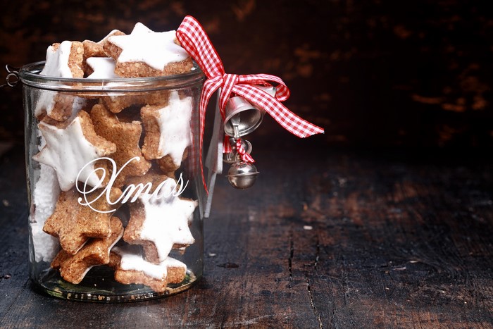 Christmas star cookies in a jar with ribbon and bells