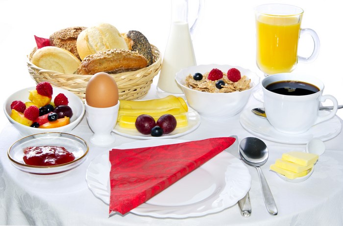 Breakfast with coffee, juice, muesli, bread, and egg