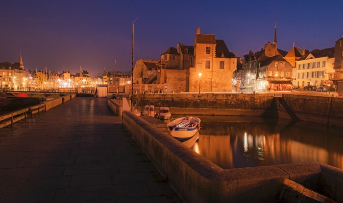Honfleur, France harbor at night with illuminated buildings and boats