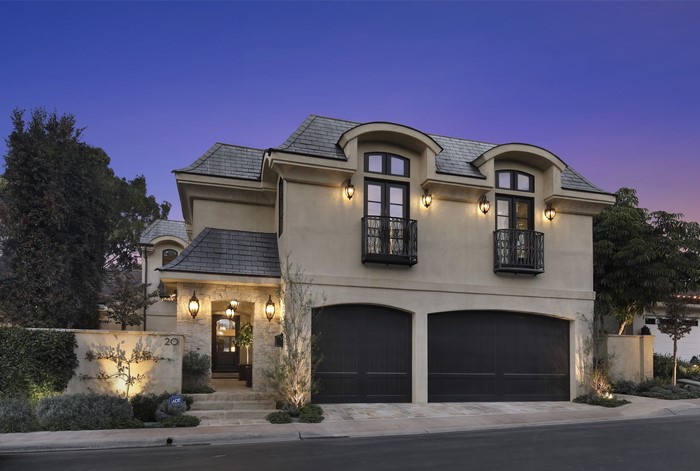 Luxury French-style house with garage at dusk