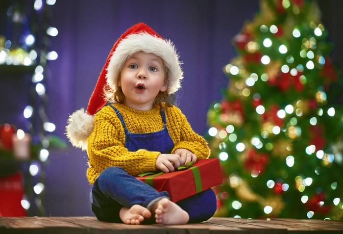 Little girl in Santa hat with Christmas gift