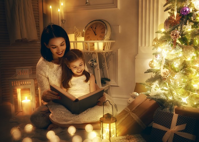 Mother and Daughter Reading by Christmas Tree