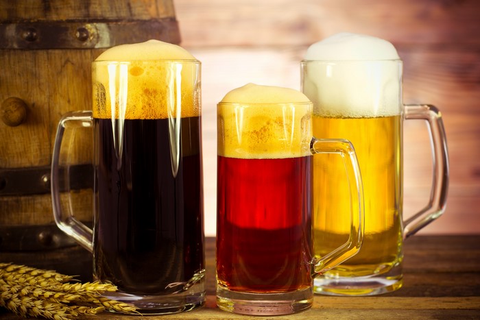 Three Mugs of Beer with Barrel and Wheat