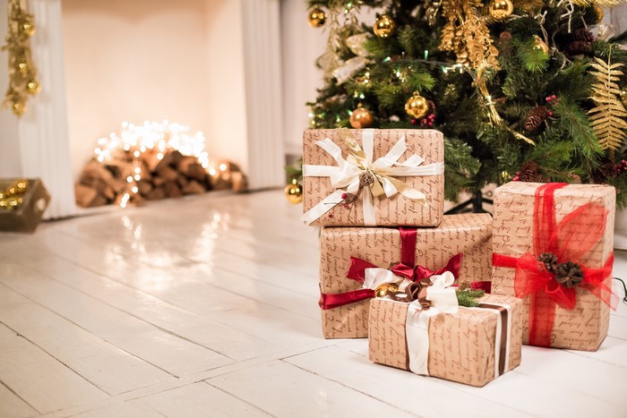 Christmas gifts by a decorated tree and fireplace