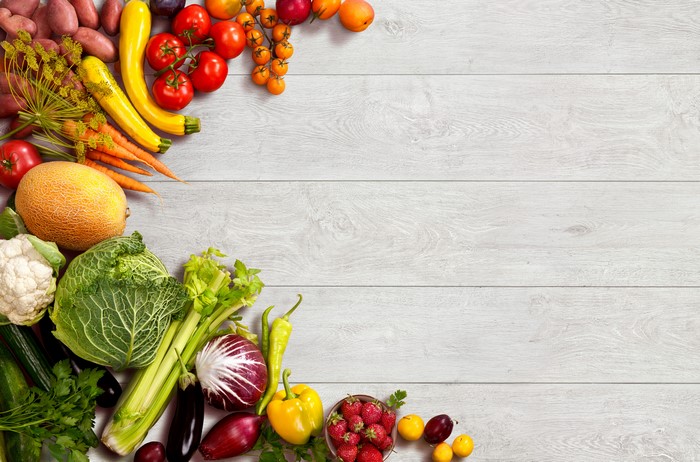 Assortment of Fresh Vegetables and Fruits on Wood Planks