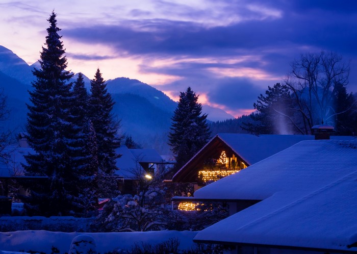 Snowy Bavarian village at dusk with mountain backdrop