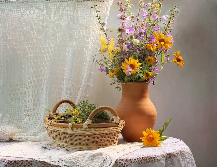 Still-life with wildflowers in a vase and basket