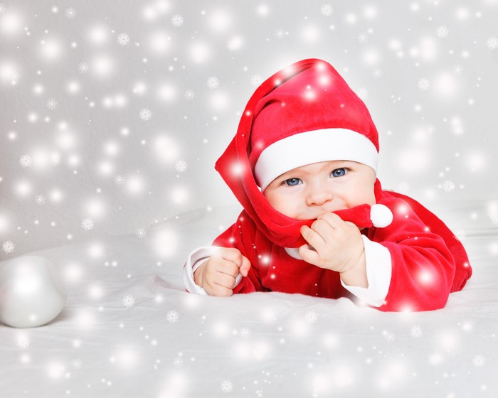 Baby in Santa costume with snowflakes