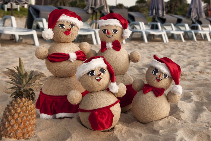 Christmas snowmen on a beach with a pineapple