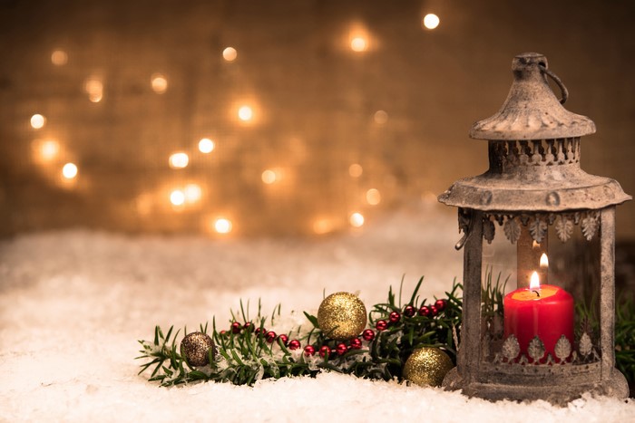 Christmas lantern with candle and decorations in snow