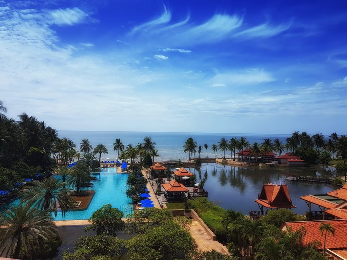 Resort with pools and palm trees by the sea in Thailand