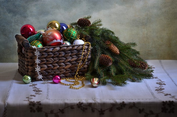 Christmas ornaments in a wicker basket with pine cones and branches