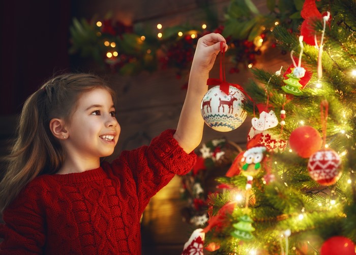 Girl decorating Christmas tree with ornaments
