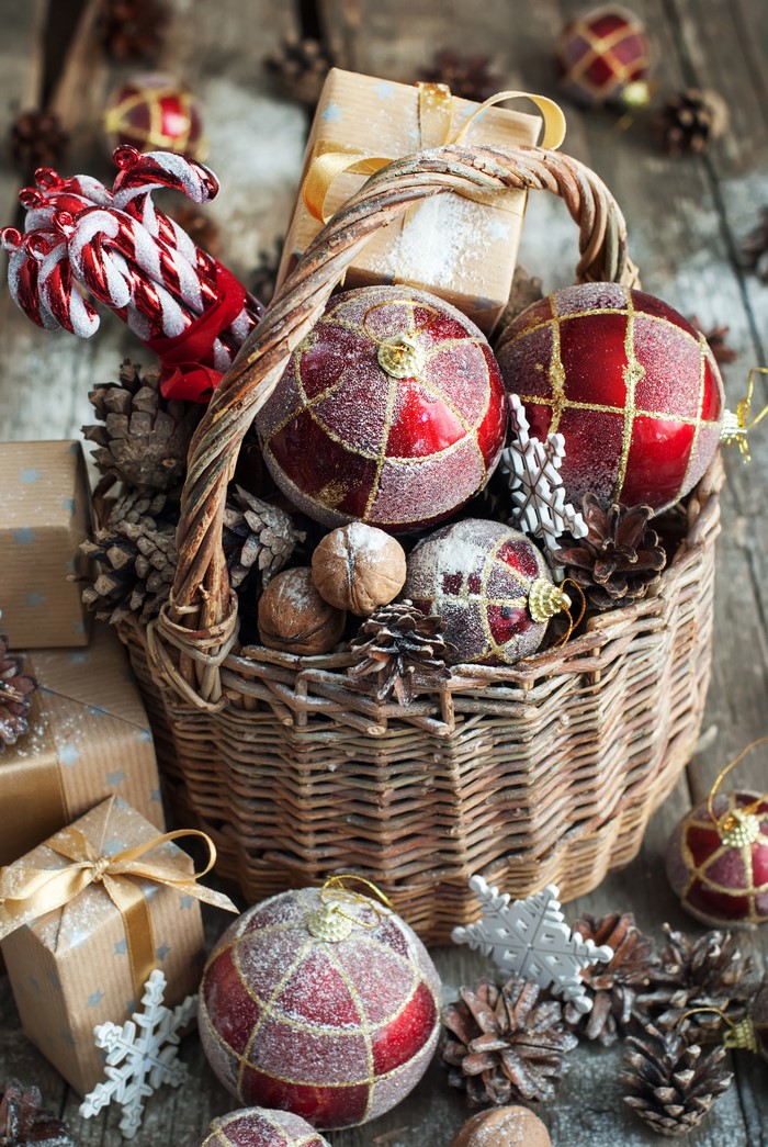 Christmas basket with ornaments, gifts, and pine cones