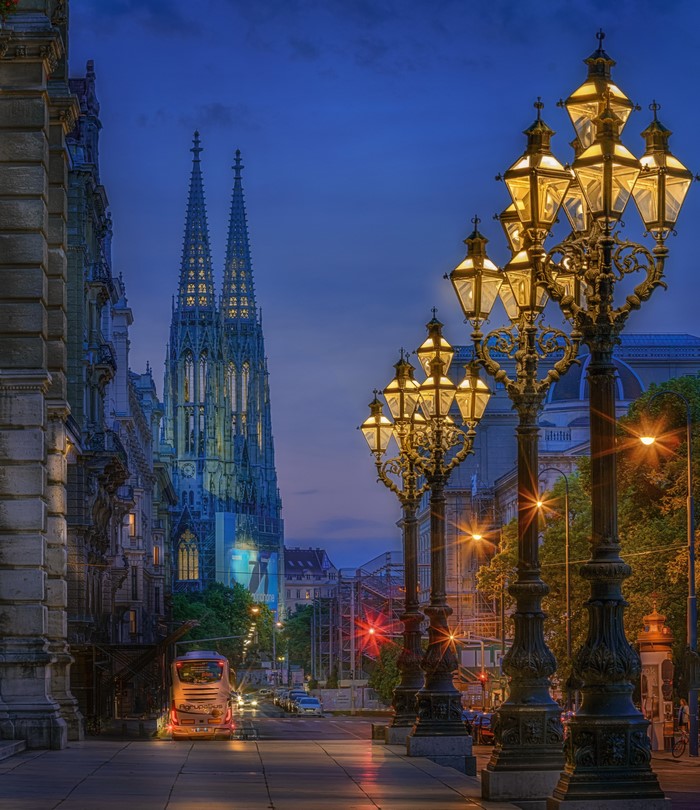 Street lights and cathedral in Vienna at dusk