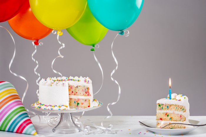 Birthday cakes with balloons and party hat