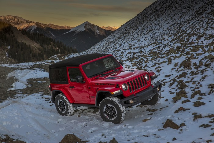 Red Jeep Wrangler Rubicon on snowy mountain