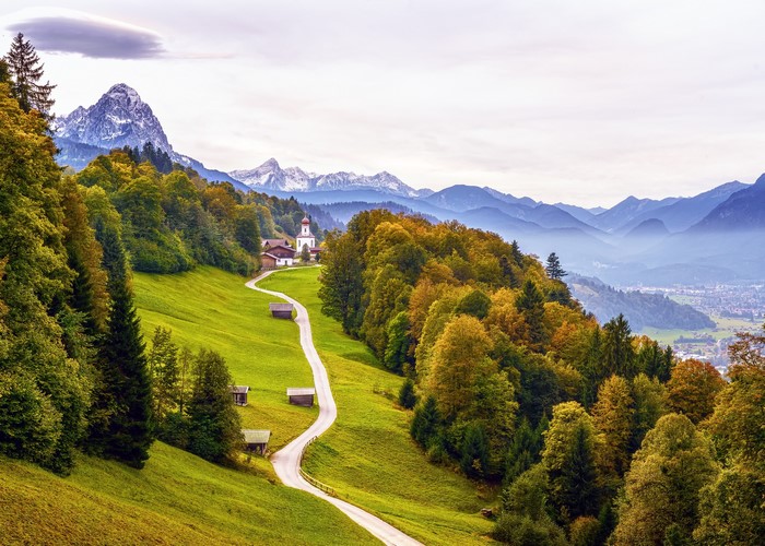 Autumn road to a church in the Bavarian Alps