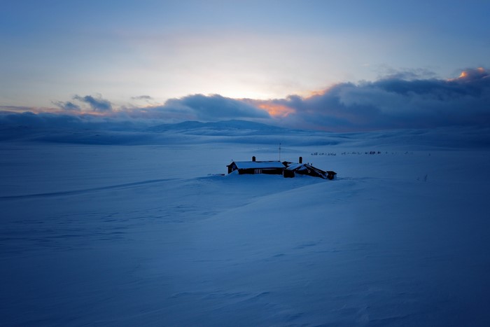 House in a snowy landscape at sunset