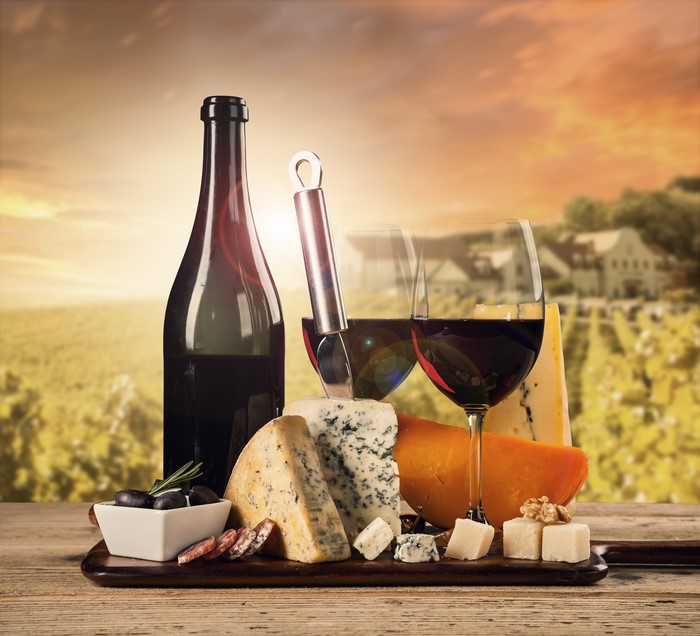 Wine bottle and glasses with cheese and sausage