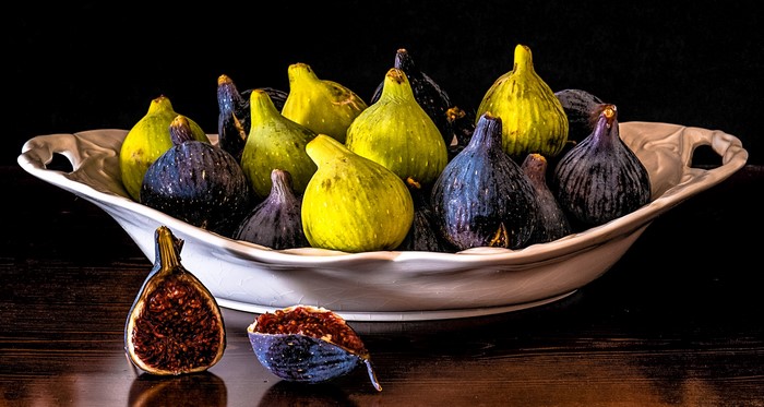 Bowl of fresh figs, one cut in half
