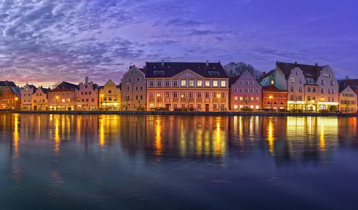 Row of historic buildings on a river at dusk in Landshut, Germany