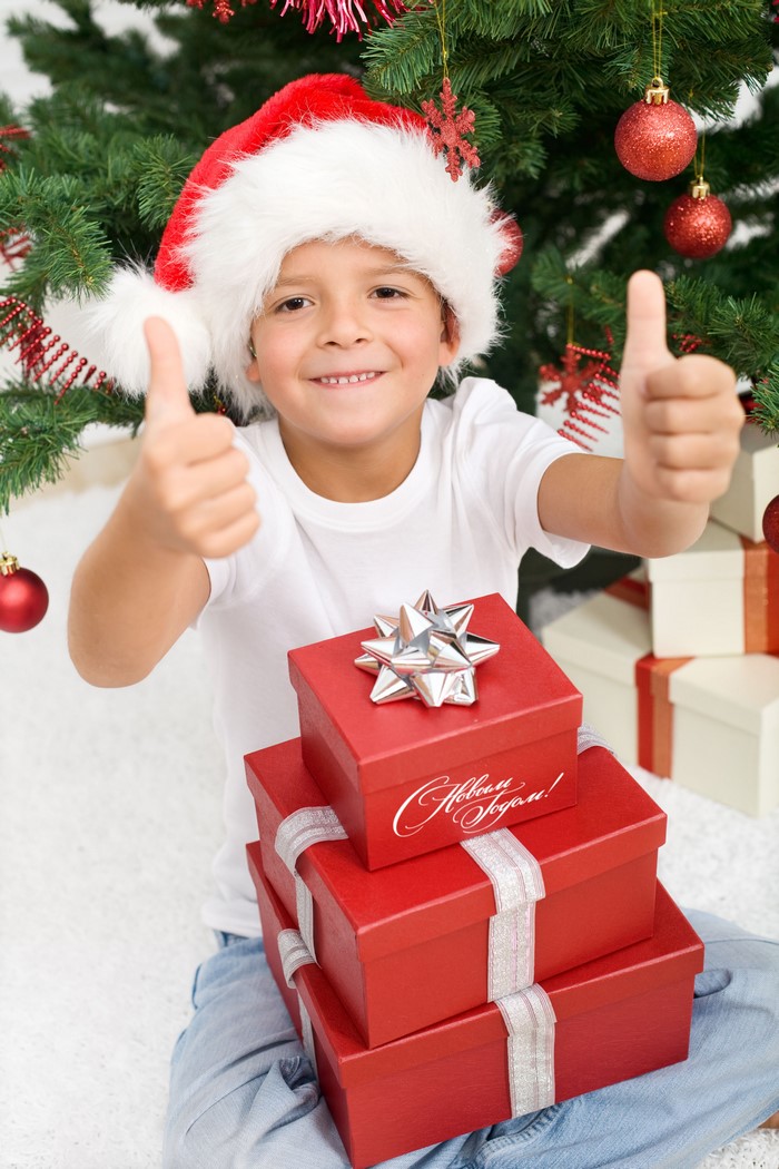 Boy in Santa hat with Christmas gifts