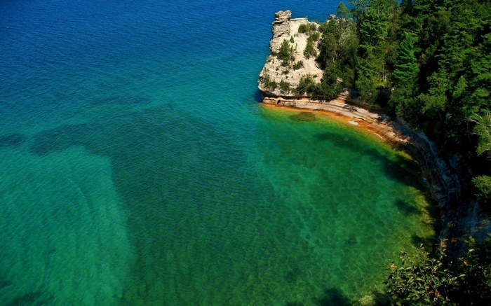 Rocky cliff face jutting into clear turquoise water