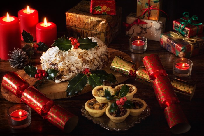 Christmas still-life with cake, mince pies, crackers, candles, and gifts