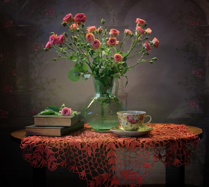 Still-life with roses, books, and a teacup on a table